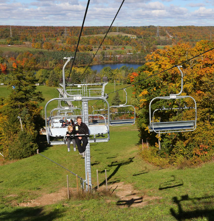 Father and daughter riding chairlift at Kelso
