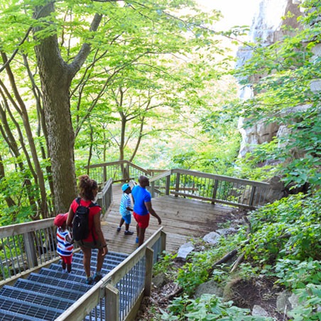 A father and mother walk down the stairs installed at rattlesnake point with their two young children
