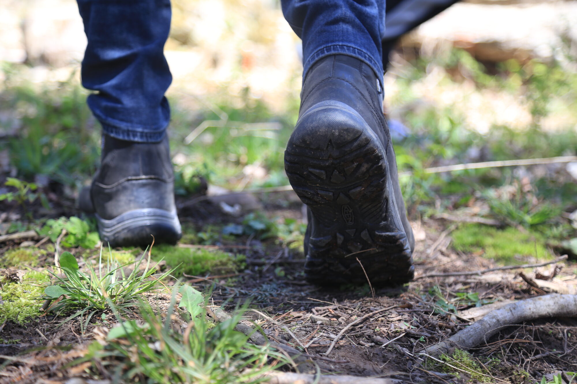 a close up of an individual's boots while they walk away from the camera
